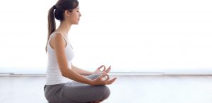 Como melhorar a concentração: fotografia de uma mulher praticando ioga.