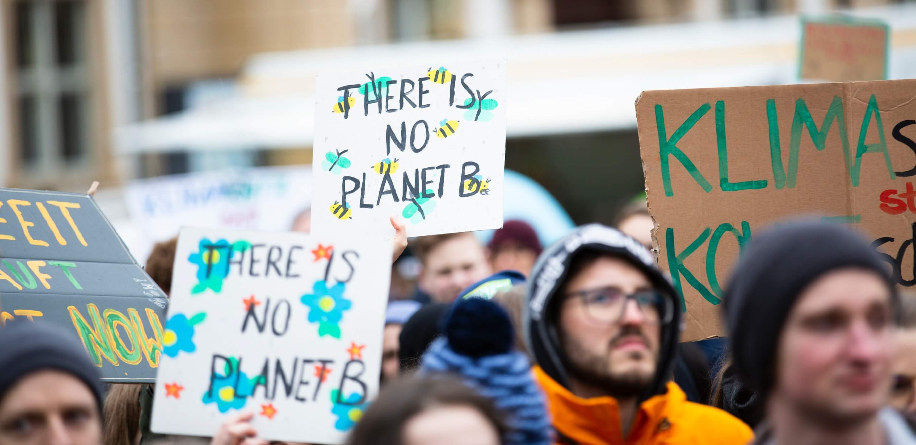 Gomifes: fotografia de uma manifestação com pessoas segurando cartazes com oi escrito “there is no planet B”