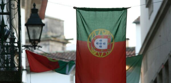 Como estudar em Portugal pelo Enem: fotografia de uma bandeira de Portugal pendurada em uma casa.
