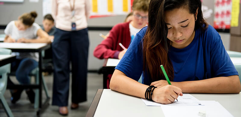 Prova de linguagens Enem 2019: fotografia de uma sala de aula fazendo prova com destaque para uma menina à frente.
