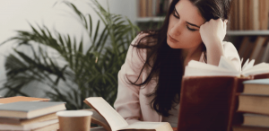 Romantismo: imagem de uma estudante em uma biblioteca lendo um livro.