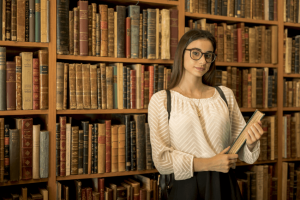 Letras: imagem de uma menina na biblioteca segurando um livro