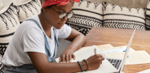 Como usar a vírgula: imagem de uma jovem estudando com seu notebook e anotações