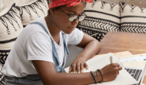 Como usar a vírgula: imagem de uma jovem estudando com seu notebook e anotações