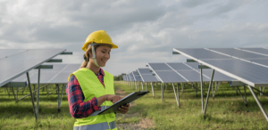 Engenharia Ambiental: imagem de uma engenheira ambiental fazendo suas análises em um campo coberto de energia solar