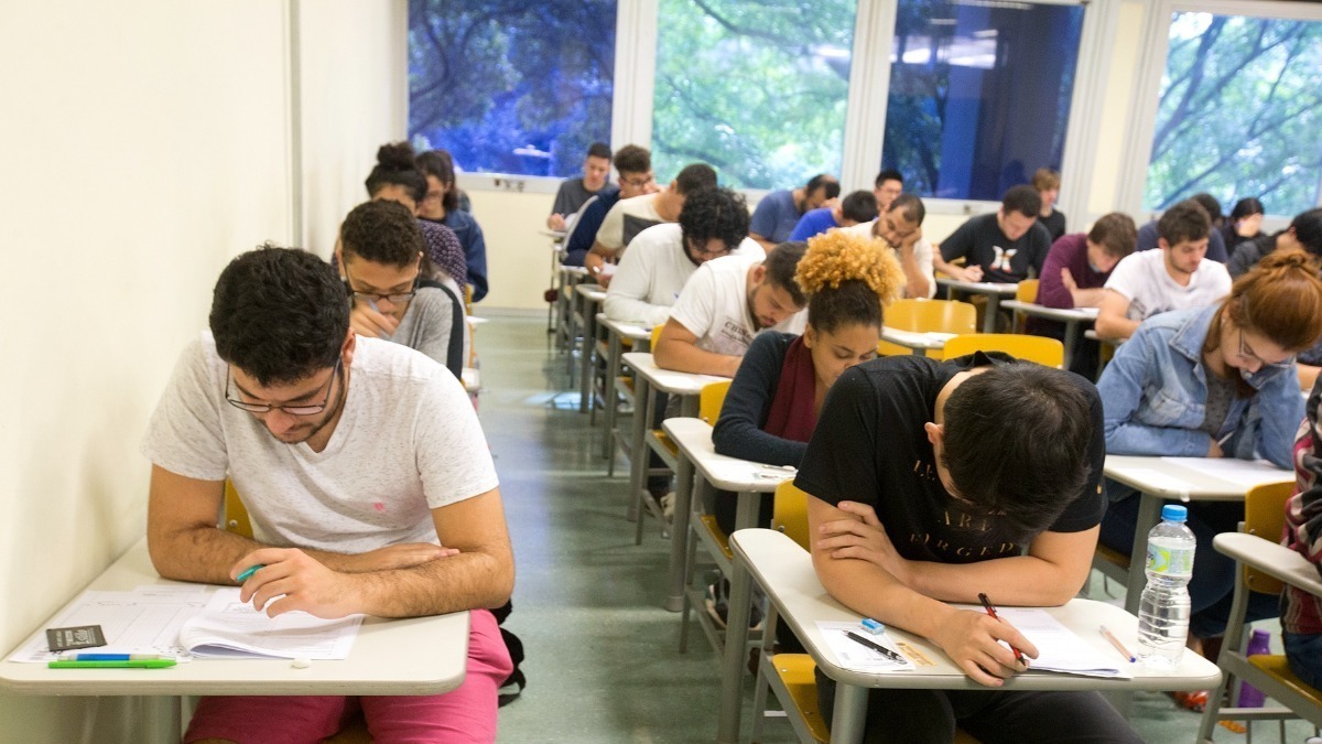 pessoas fazendo prova em sala de aula, gabarito fuvest 2025