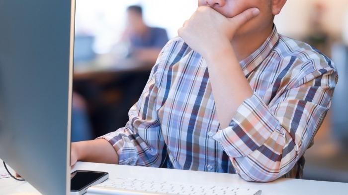 pessoa mexendo em computador em ambiente corporativo, mercado de trabalho inteligência artificial redação pronta