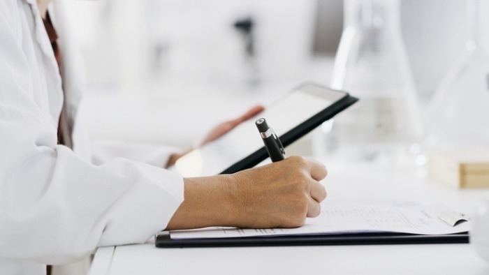 pessoa médica escrevendo em um papel, enare novo