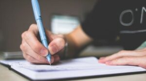 pessoa escrevendo em caderno, como escrever redação nota 1000