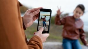 mãe tirando foto do filho, os perigos do compartilhamento de fotos de crianças nas redes sociais, redação pronta