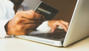 pessoa com cartão de crédito em um computador, vício em apostas bets jogos de azar redação
